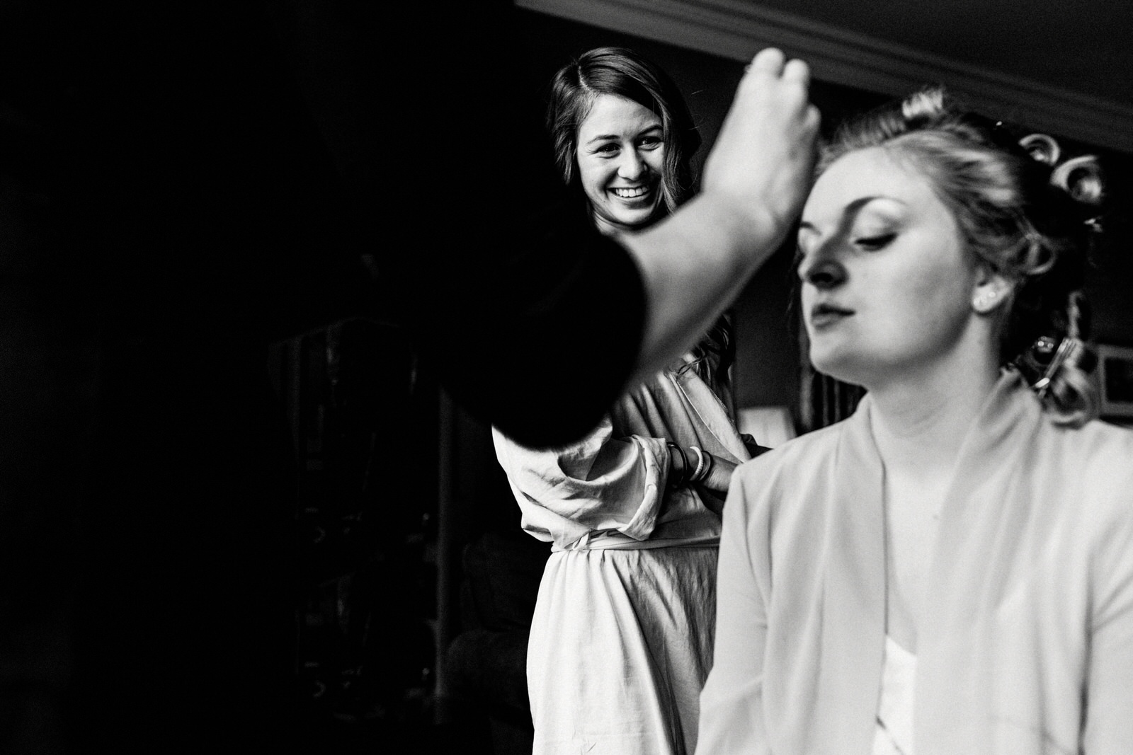 bride getting ready in window light at ashdown park hotel