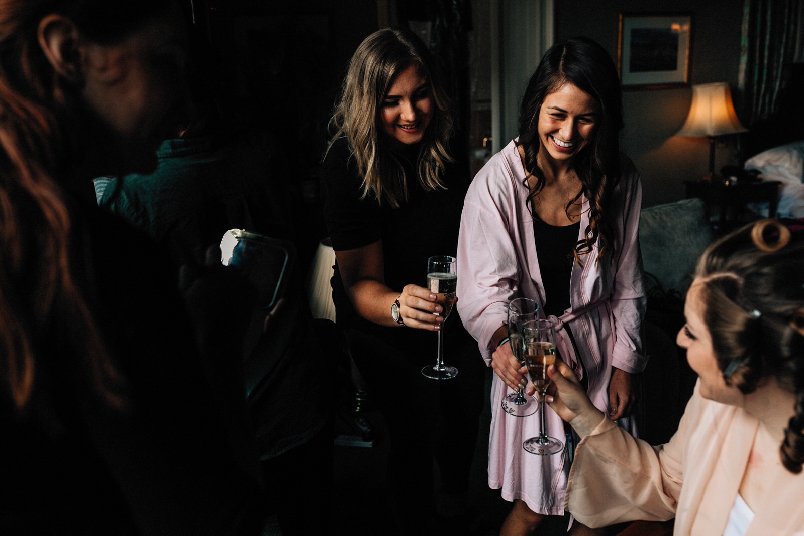 bidesmaid laughing at bride with champagne