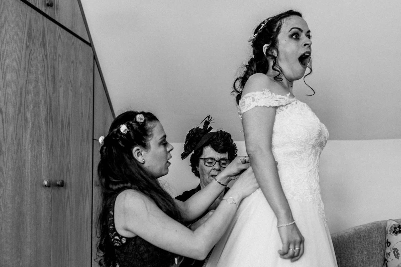bride getting into dress with shocked face