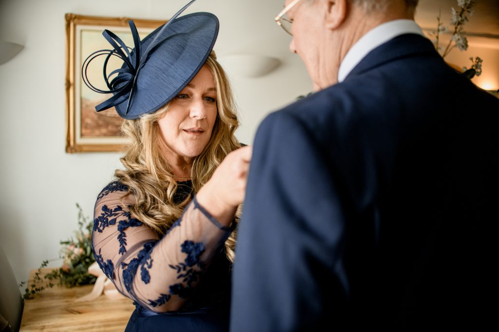 mother of the bride tying tie