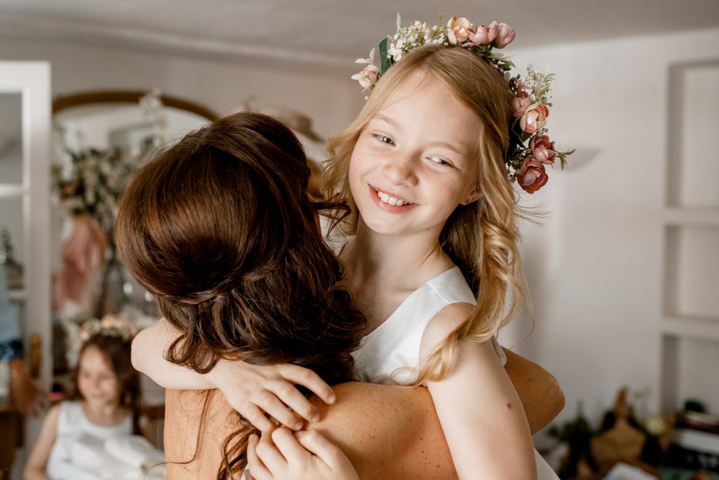 flower girl hugging bride