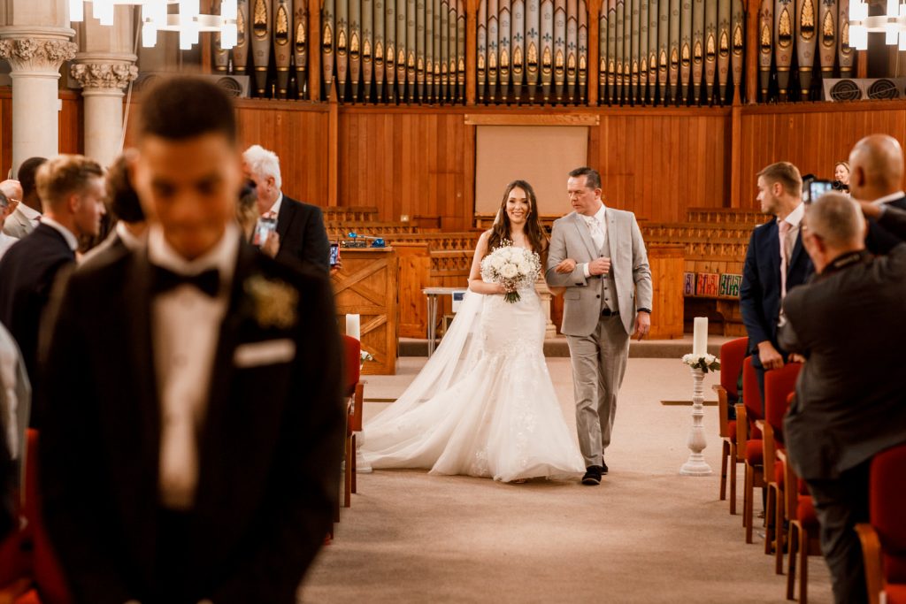 bride walking down aisle with father