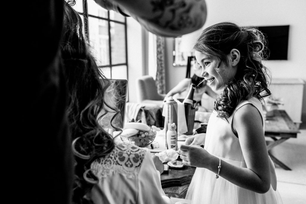daughter looking at mother whilst she prepares makeup for wedding