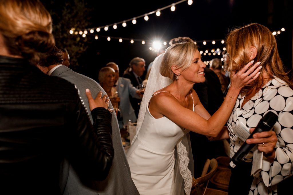 bride kissing mother on wedding day