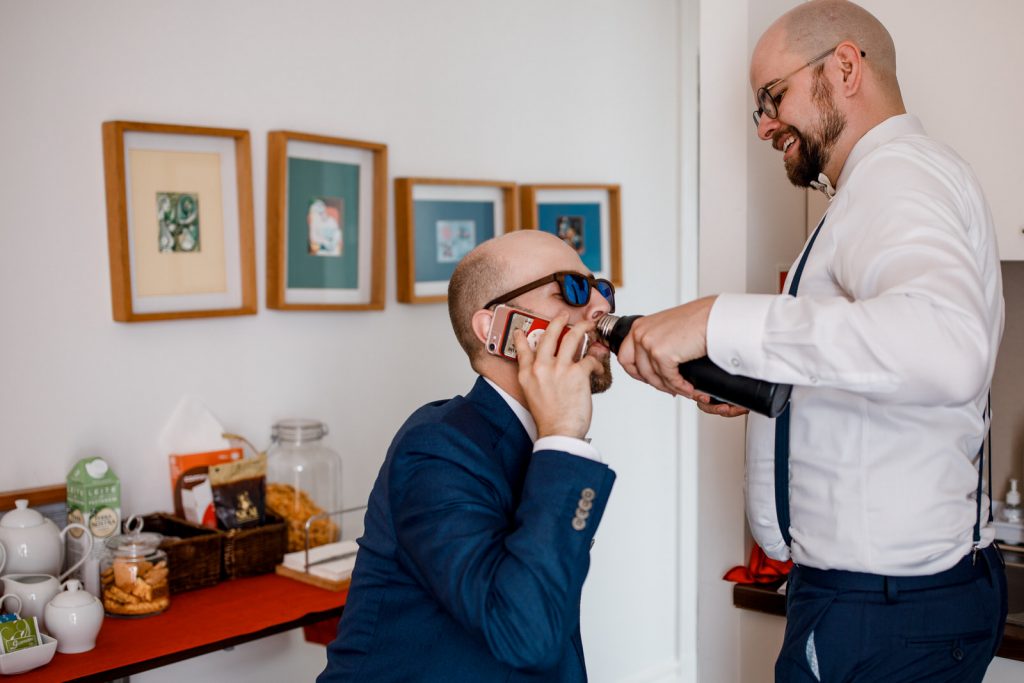 groom drinking from bottle before wedding