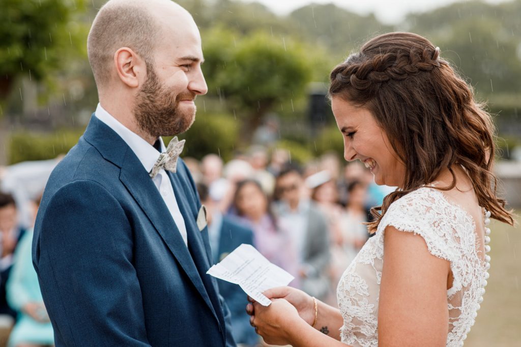 bride and groom standing in rain at destination wedding