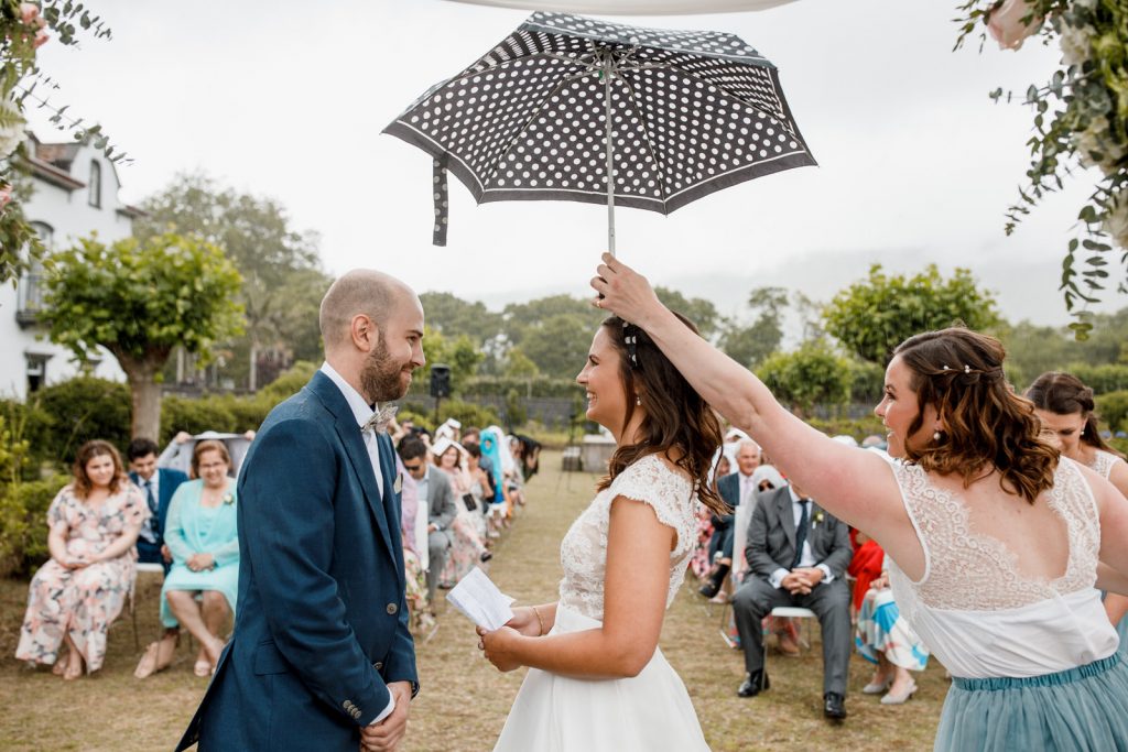 bride and groom standing in rain at destination wedding