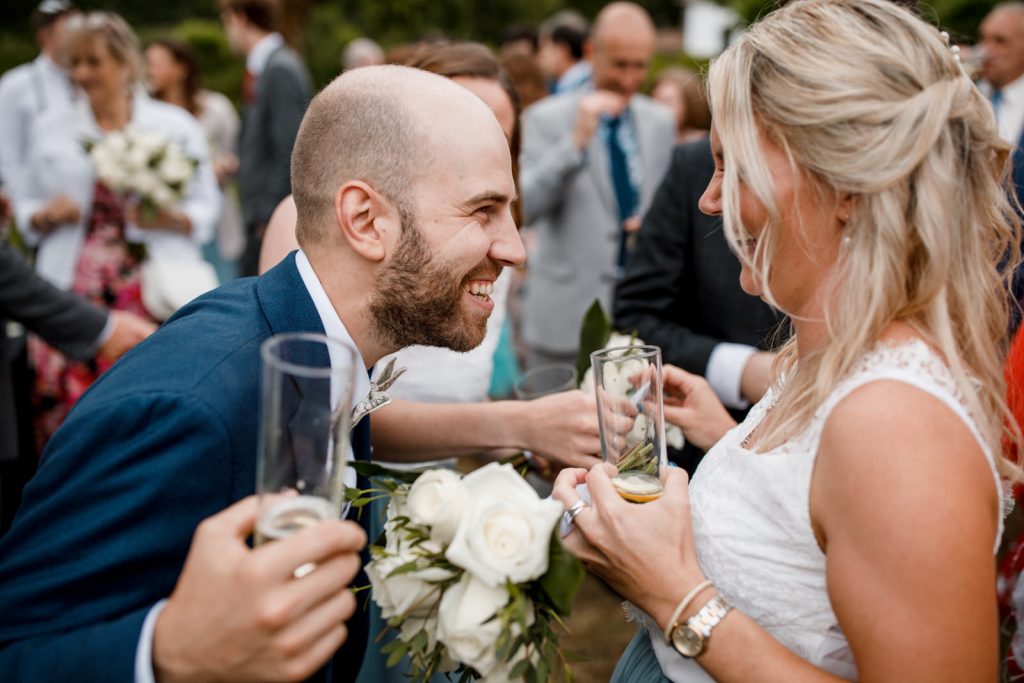 groom laughing with bridesmaid