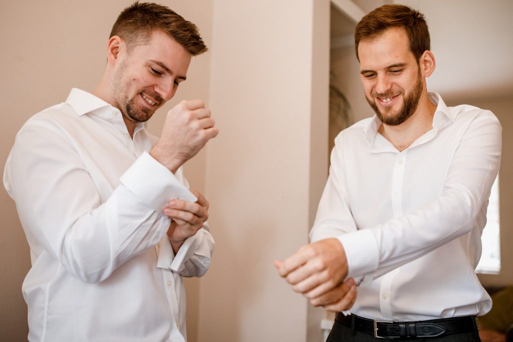 groom fixing cufflinks