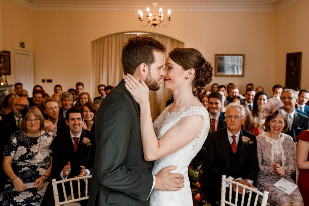 bride and groom first kiss at richmond park wedding