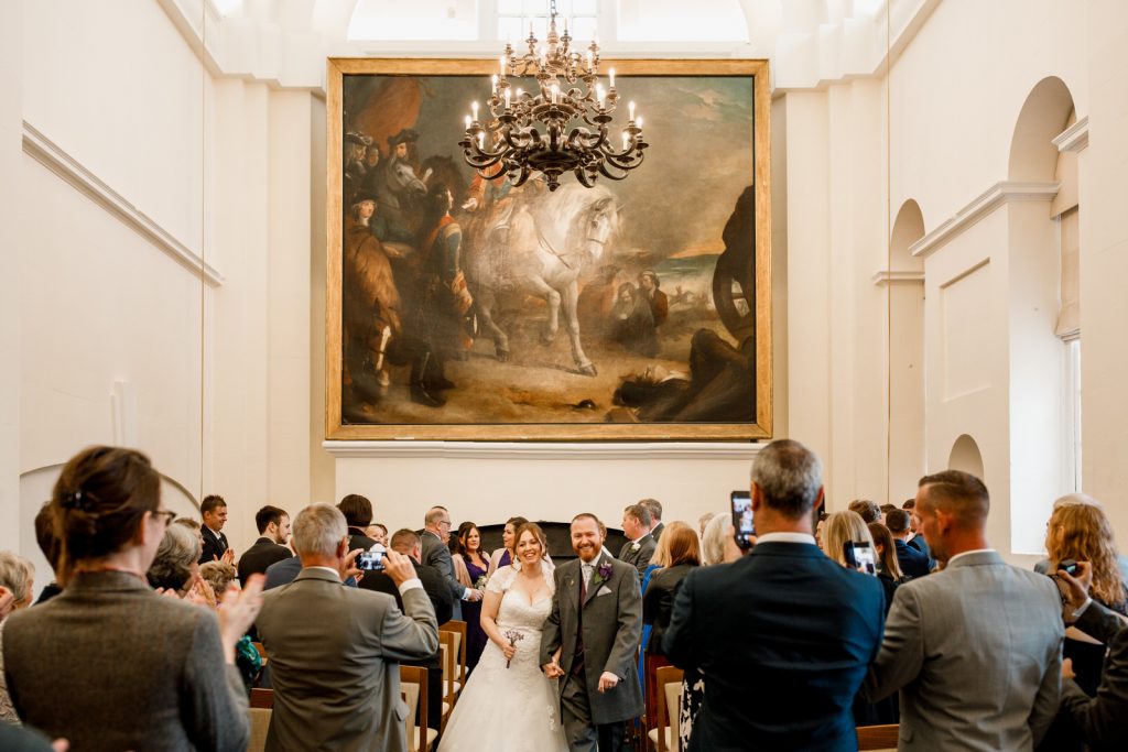 bride and groom walking down the aisle at blenheim palace