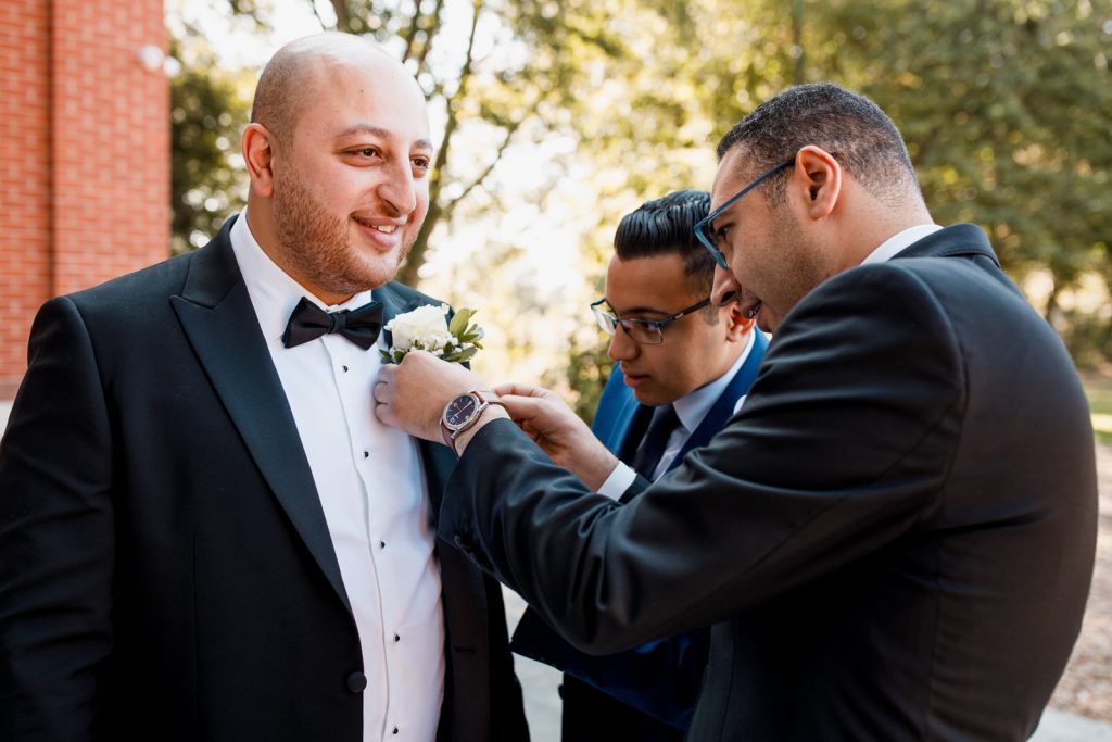groom having flower pinned to lapel