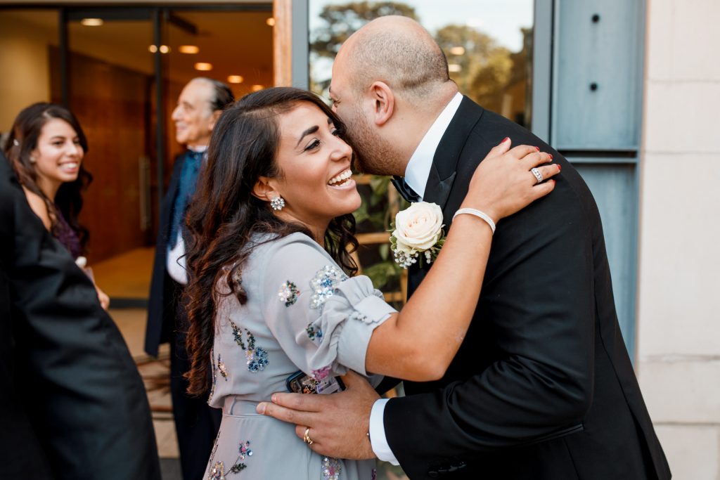 groom being hugged at wedding