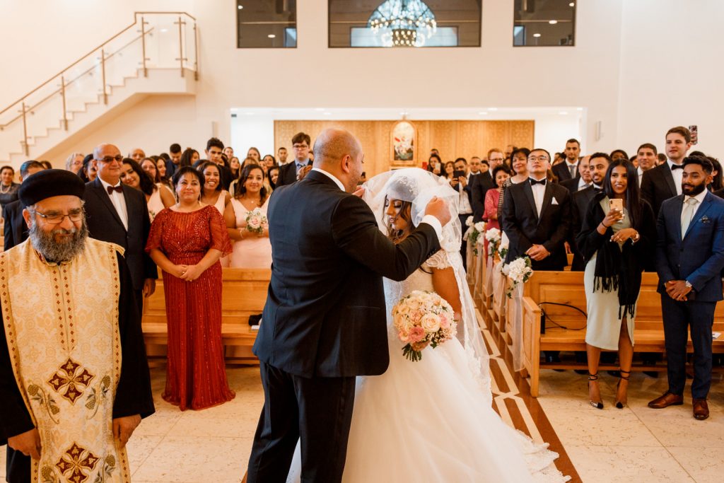 groom lifting veil of bride at wedding