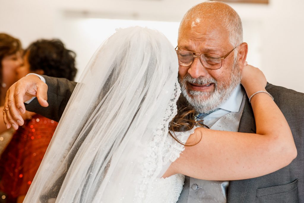 father embracing bride and crying
