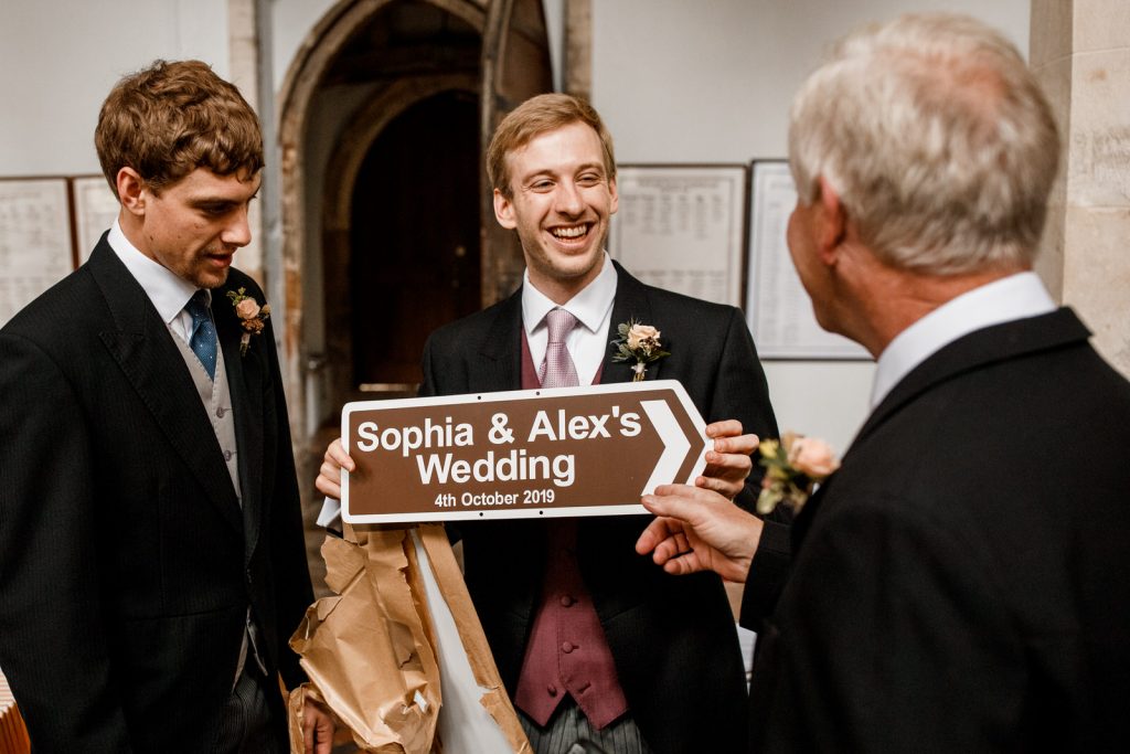 groom holding wedding sign