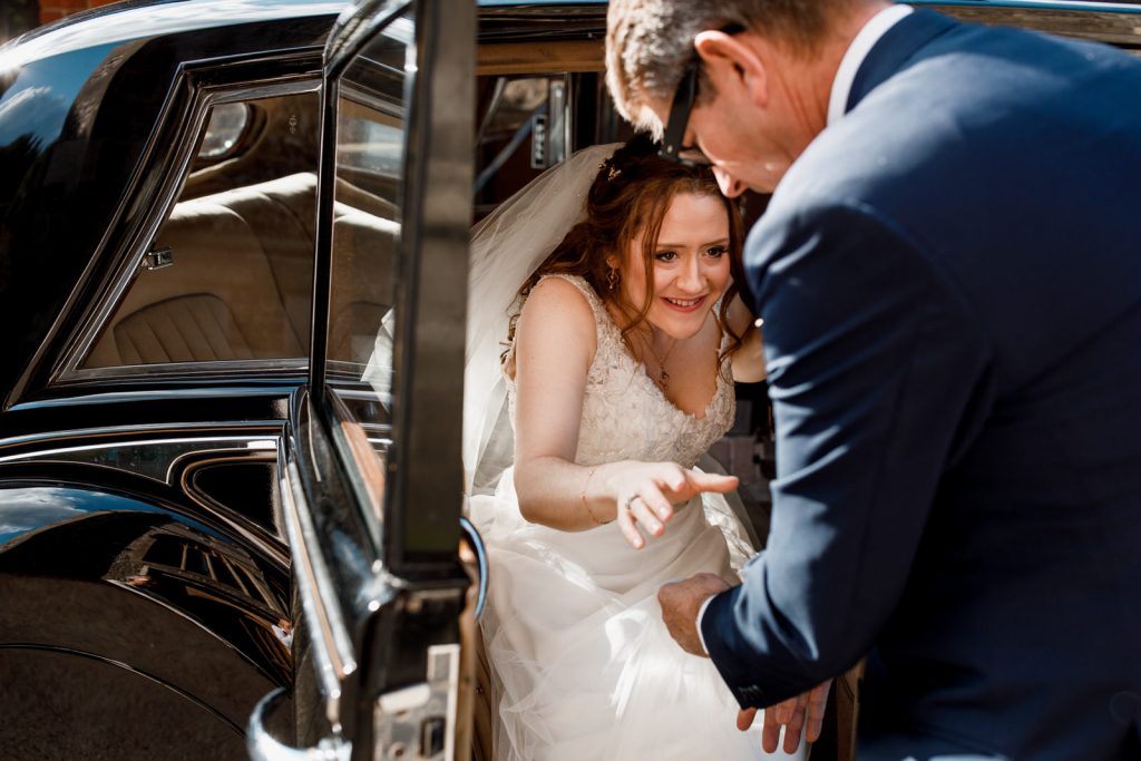 bride getting out of wedding car at hedsor house