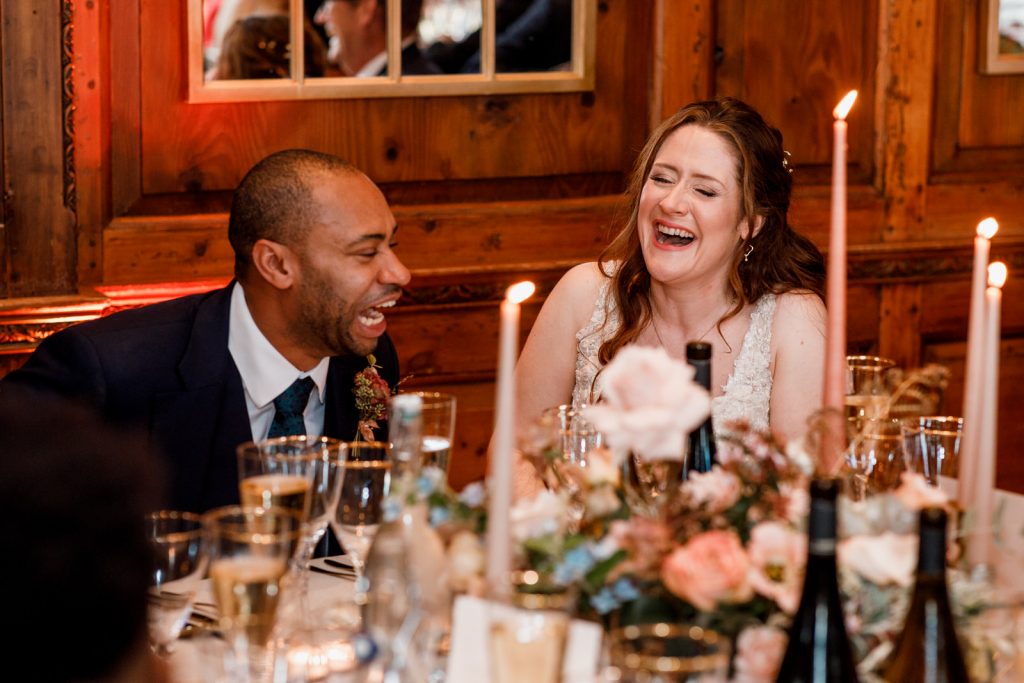 bride and groom laughing at speeches at winter wedding in hedsor house