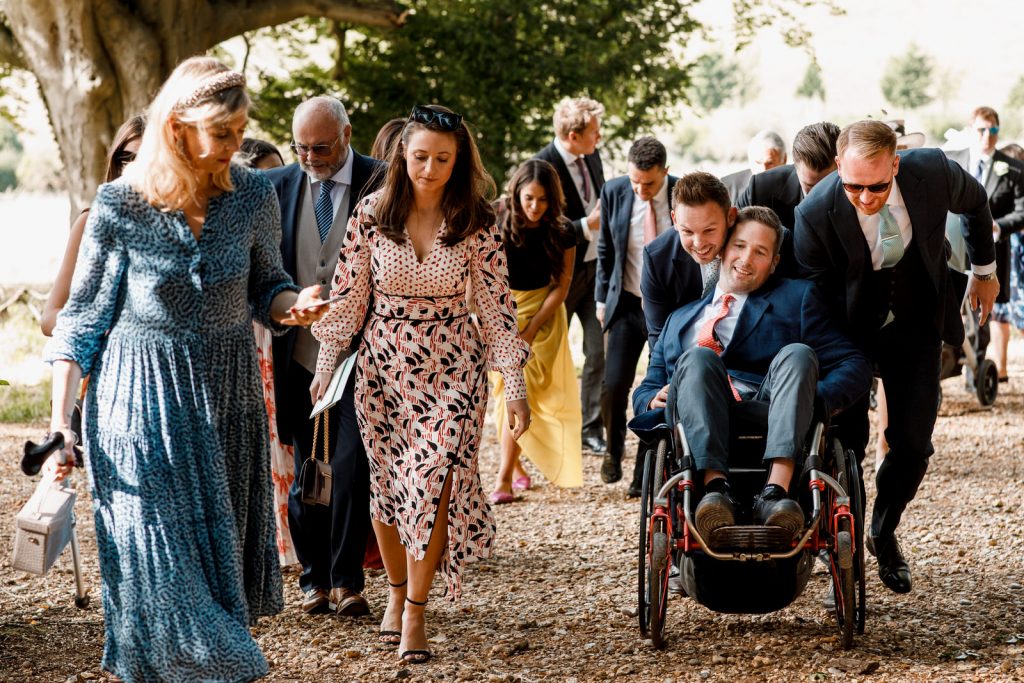 wedding guest pushing wheelchair up hill