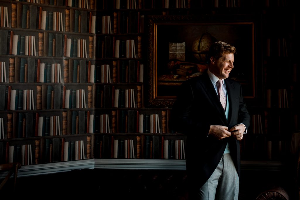 groom looking out window at hedsor house wedding