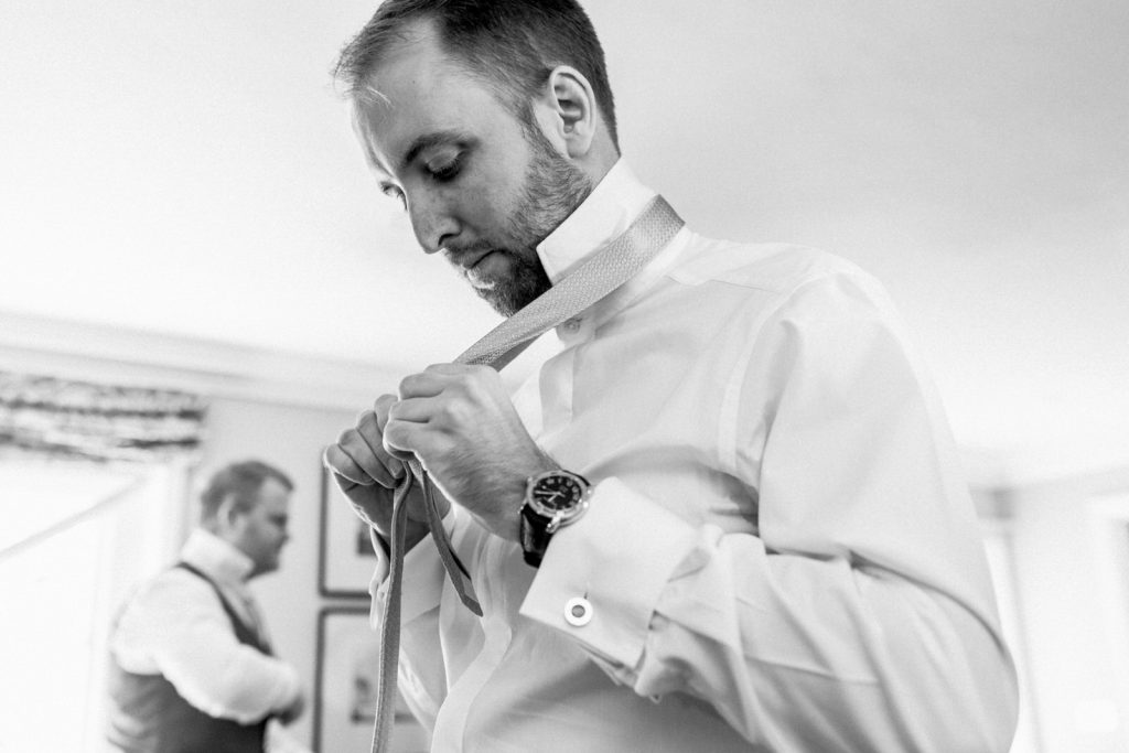 groom getting ready doing his tie up