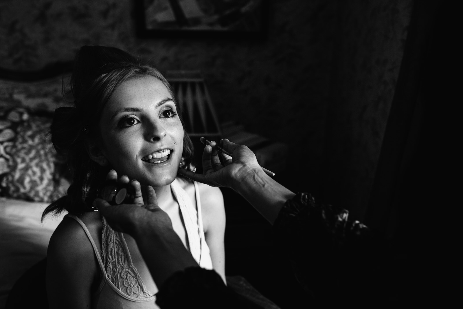 bride having make up done with light pouring on face