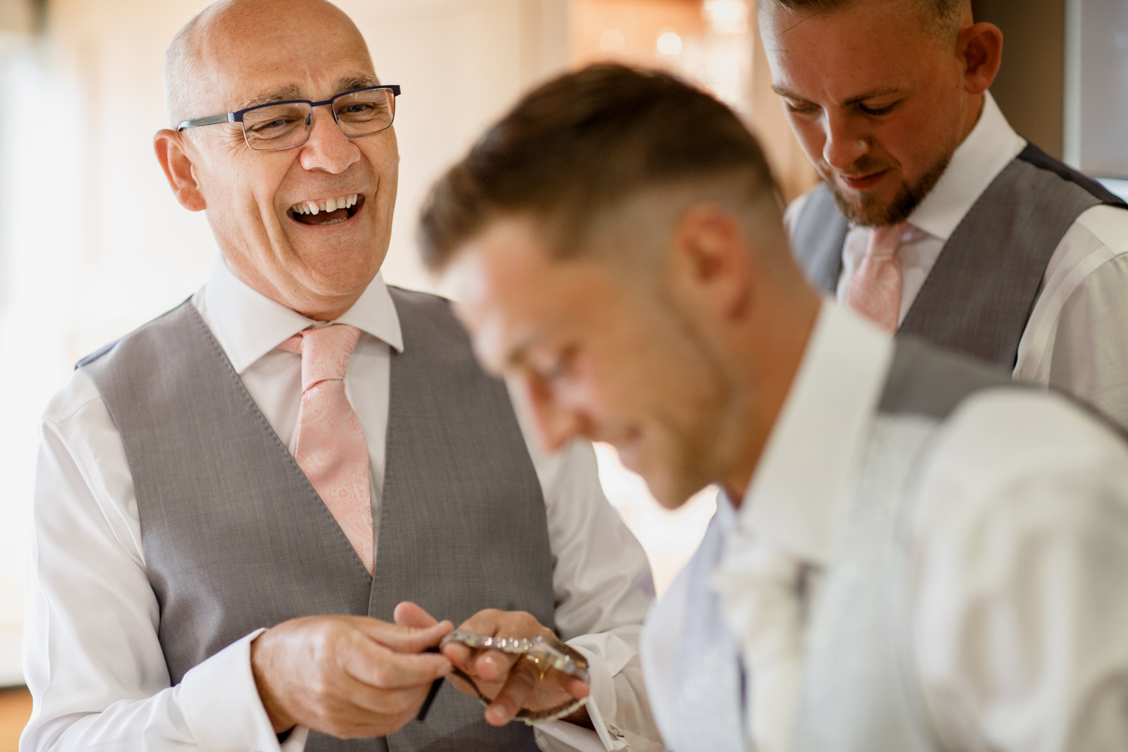 father of the groom laughing with groom