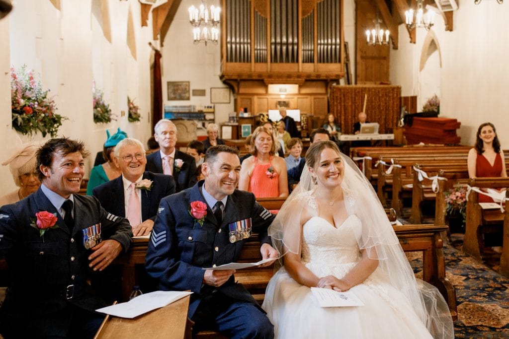 bride and groom laughing at all saints church in coleshill