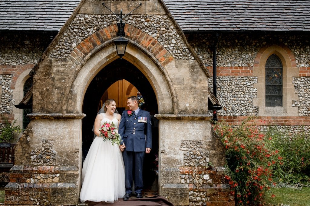 bride and groom standing outside of church