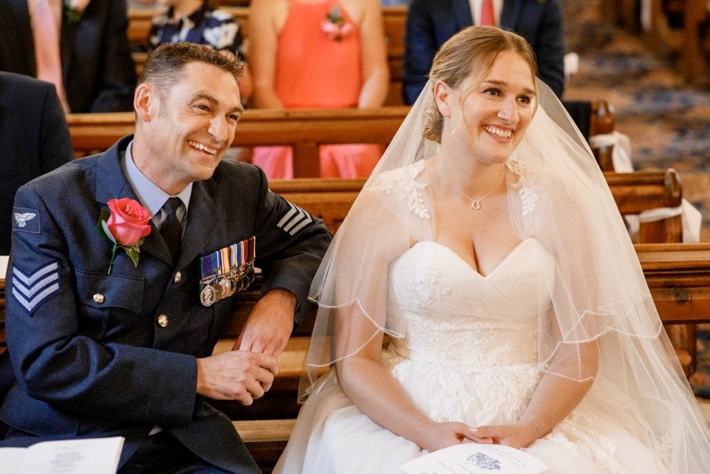 bride and groom smiling in church