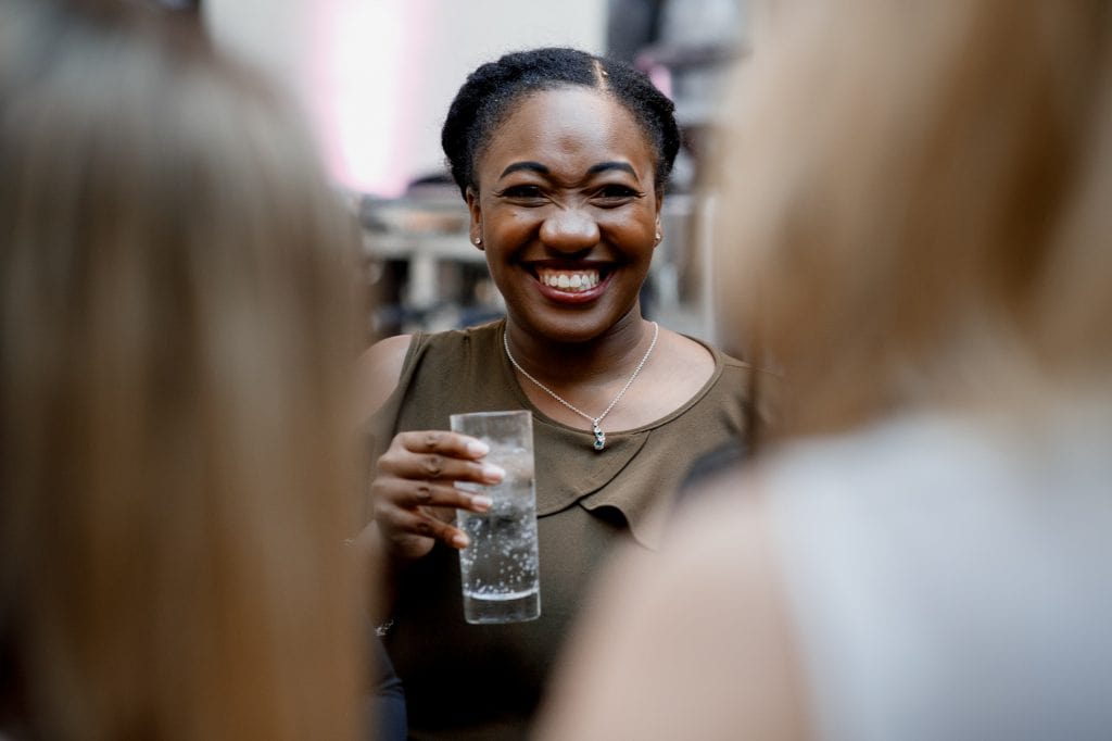 wedding guest laughing with drink in hand