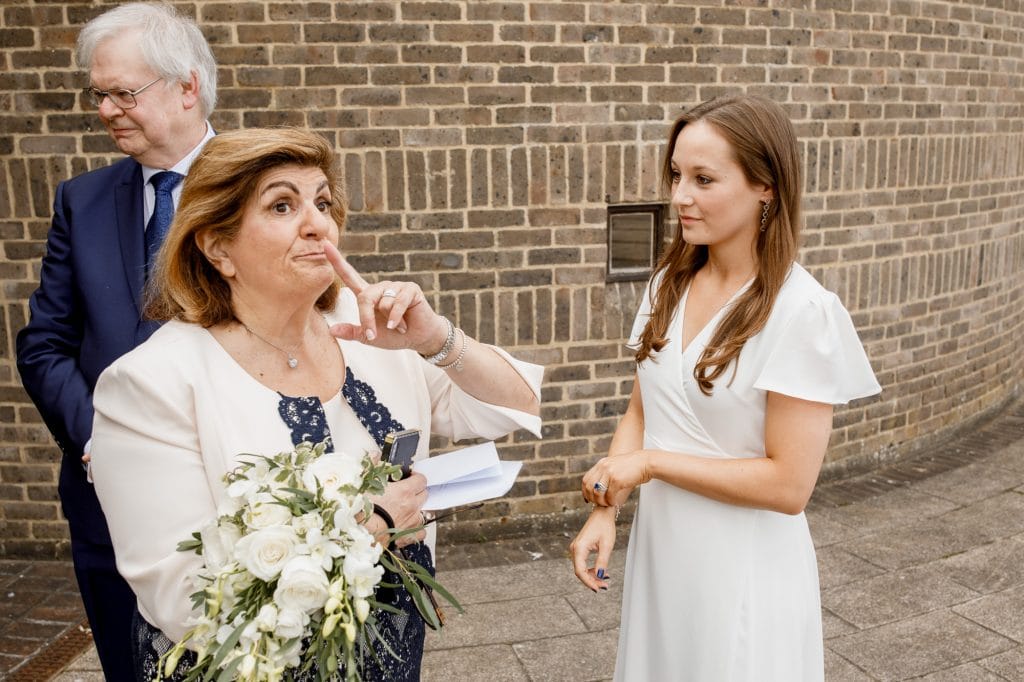mother of the groom holding finger to lips