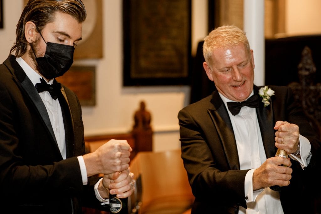groom and best man opening champagne