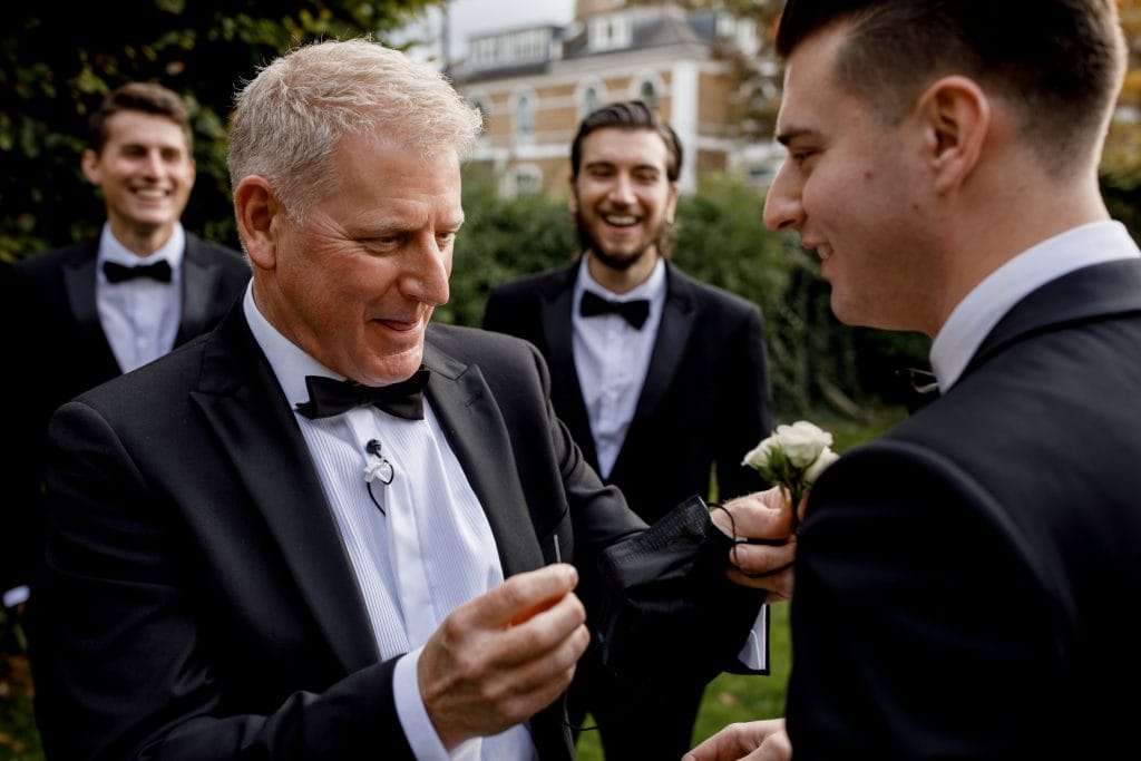 father of the groom pinning lapel flower